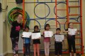 Lil' Buds proudly showing their Grade One and Grade Two certificates and badges after achieving the grades in the Blossom Yoga Syllabus