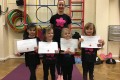 Lil' Buds proudly showing their Grade One and Grade Two badges and certificates after achieving the grades in the Blossom Yoga Syllabus
