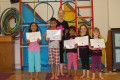Lil' Buds proudly showing their Grade One and Two certificates and badges after achieving the grades in the Blossom Yoga syllabus