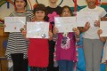 Big Buds proudly showing their Grade One, Two and Three certificates and button badges after achieving the grades in the Blossom Yoga syllabus