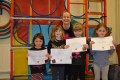 Lil' Buds proudly showing their Grade One and Two certificates and badges after achieving the grades in the Blossom Yoga Syllabus