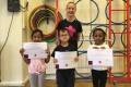 Lil' Buds proudly showing their Grade One certificates and badges after achieving the grade in the Blossom Yoga Syllabus