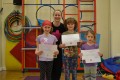 Lil' Buds proudly showing their Grade One and Three certificates and badges after achieving the grades in the Blossom Yoga Syllabus