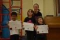 Lil' Buds proudly showing their Grade Five and Grade One certificates and badges after achieving the grades in the Blossom Yoga Syllabus