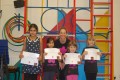 Lil' Buds proudly showing their Grade Two certificates and badges after achieving the grade in the Blossom Yoga Syllabus