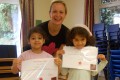  Lil’ Buds proudly showing their Grade One certificates and badges after  achieving the grade in the Blossom Yoga syllabus
