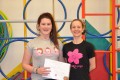Teen Bud proudly showing her Grade One certificate and button badge after achieving the grade in the Blossom Yoga Syllabus